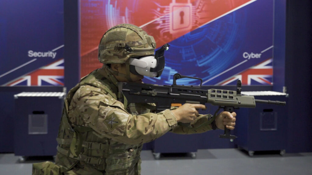 Military personnel in full gear engaging with AVRT virtual reality simulation. The soldier is actively participating in a training scenario, using equipment and interacting with their surroundings. The virtual environment is designed to simulate real-life military situations, enhancing their skills and preparedness