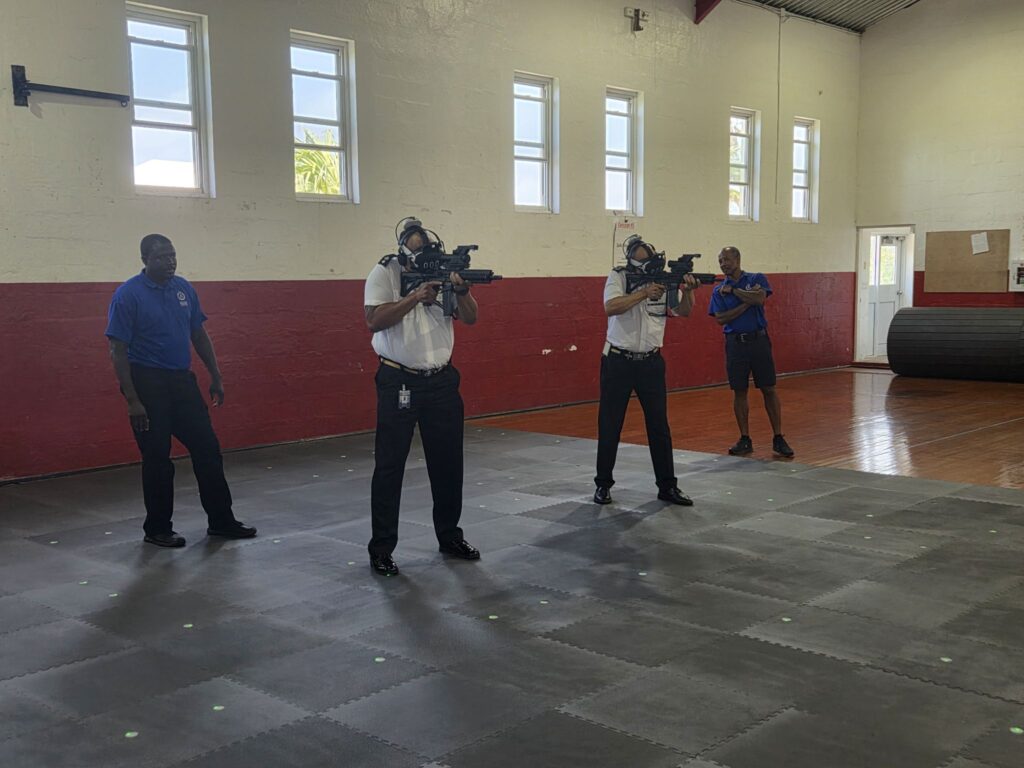 Two Bermuda Police Service officers training with AVRT tracked carbine surrogates as colleagues observe